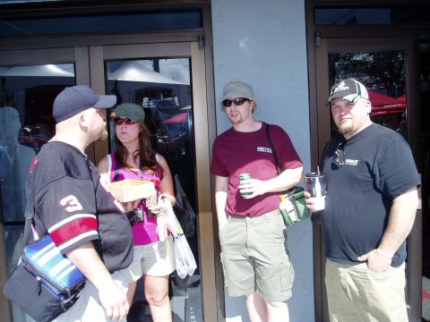 2000 Ford E350 - A group of four people are gathered outside a building, some holding drinks and food.