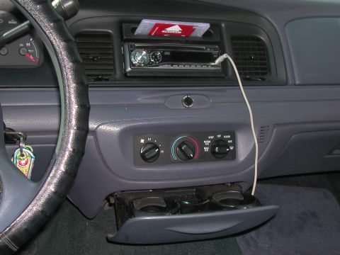 1999 Ford Crown Victoria - The interior of a car shows the dashboard with the radio and climate controls visible.