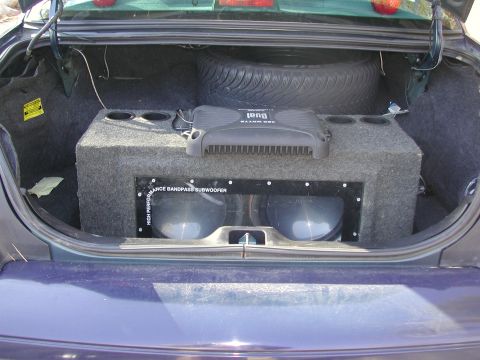 1999 Ford Crown Victoria - The trunk of a 1999 Ford Crown Victoria contains a large subwoofer enclosure and a spare tire.