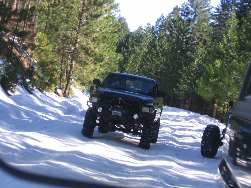 Black off-road truck with winch and large tires on a snowy road