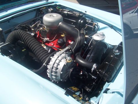 1973 Ford Mustang - Close-up view of a car's engine bay, showing the engine, air intake, and radiator.