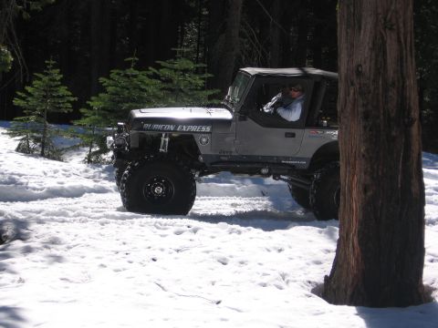 1989 Ford Bronco - A modified Jeep Wrangler navigates a snowy forest road.