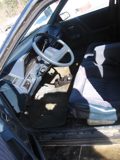 1999 Ford Taurus - The interior of a car, a blue dashboard and seats, is shown from the passenger side.
