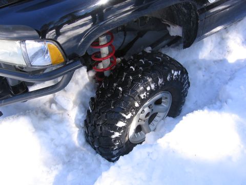 1989 Ford Bronco - Vehicle's front tire and suspension system are buried in snow.