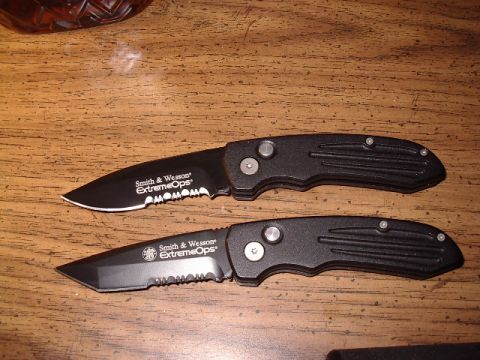 1985 Ford Bronco - Two Smith & Wesson Extreme Ops folding knives are displayed on a wooden table.