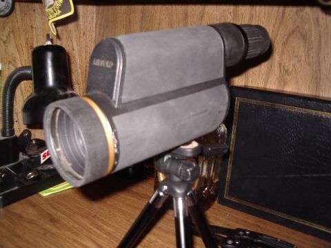 1985 Ford Bronco - A spotting scope is mounted on a tripod, positioned on a wooden surface.