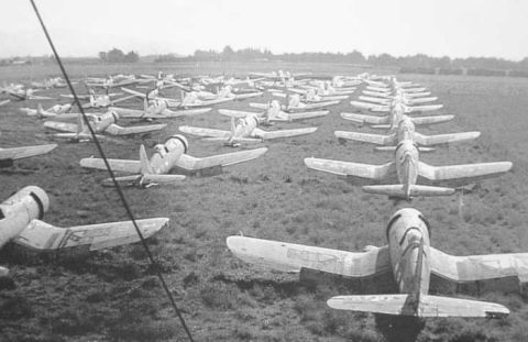 1969 Lincoln Continental - A large number of airplanes are parked in rows on a field, suggesting a storage or decommissioned area.
