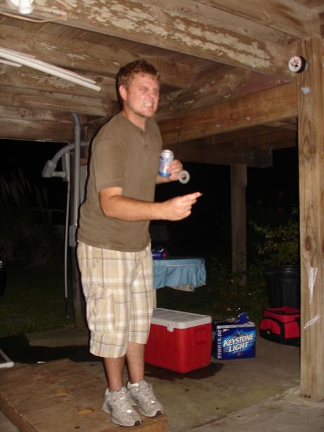 1996 Ford F-150 - A man gestures while holding a beverage can, with coolers and a trash can visible in the background.