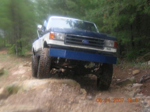 1991 Ford F-150 - A blue and white 1991 Ford F-150 navigates a challenging rocky trail.