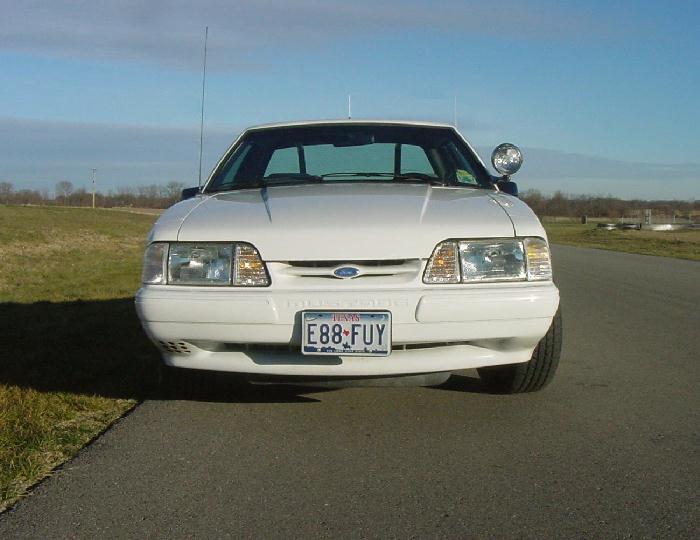 Front view of a white 1993 Ford Mustang with a license plate reading E88-FUY