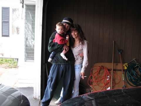 1996 Ford Probe - A man holds a child while a woman stands beside him in a garage.