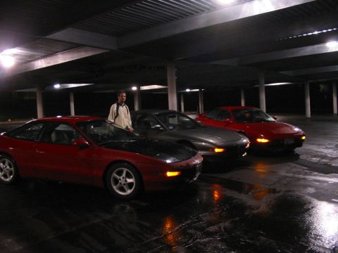 1996 Ford Probe - Three Ford Probes are parked in a dimly lit, covered area with wet pavement.