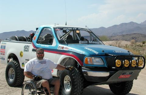 2000 Ford F-150 - A man poses with his custom Ford F-150 truck, modified for off-road use in a desert environment.