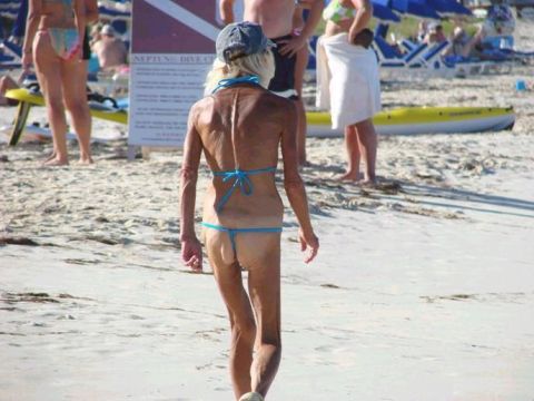 1998 Ford F-150 - A woman walks along a crowded beach on a sunny day.