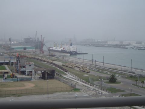 1989 Ford Bronco - A wide view of a busy port with cargo ships docked and train cars lined up on the tracks.