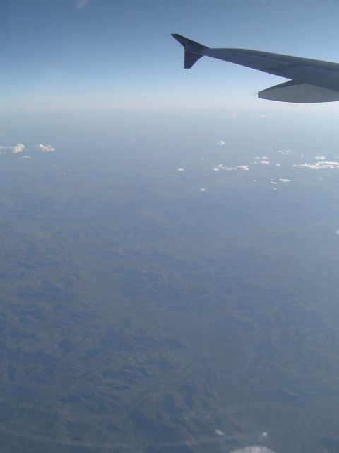 1989 Ford Bronco - View from an airplane window shows the wing and the land far below.