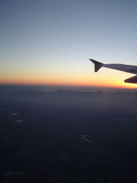 1989 Ford Bronco - View from an airplane window during sunset, showing the wing and the landscape below.