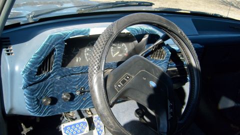 1995 Ford C-150 (Centurion Conversions) - The dashboard of a 1995 Ford C-150 (Centurion Conversions) features a custom blue velvet cover and a studded steering wheel.
