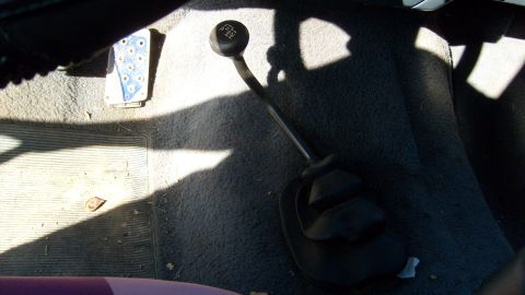 1995 Ford C-150 (Centurion Conversions) - The interior of a vehicle shows a manual transmission shifter and a textured pedal.