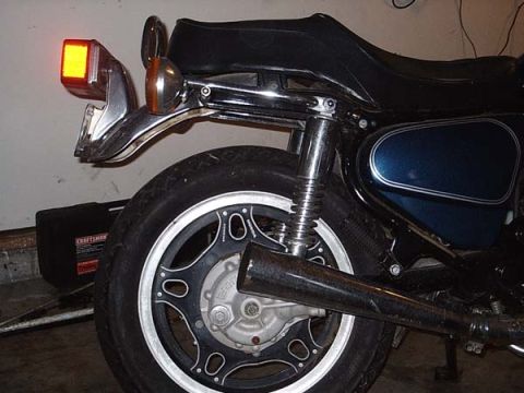 1978 Honda CB500T - The rear section of a motorcycle is visible, including its wheel, seat, and exhaust pipe. A toolbox sits in the background.