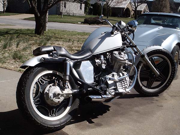Custom silver Honda motorcycle with V-twin engine parked on driveway