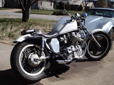 1978 Honda CB500T - A motorcycle is parked next to a car in a driveway.