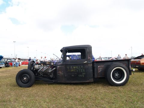 1989 Ford Bronco - This custom rat rod pickup truck features a heavily modified engine and a classic black paint job with flame accents.