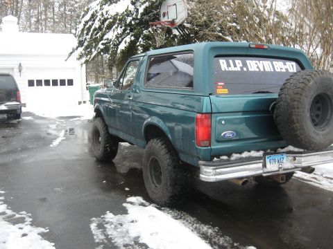 1996 Ford Bronco - A green Ford Bronco is parked in a driveway with snow on the ground and trees.