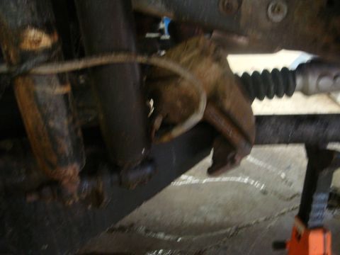 1996 Ford Bronco - Close-up view of heavily rusted brake caliper and suspension components, suggesting significant wear or disuse.