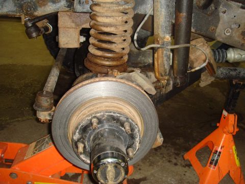 1996 Ford Bronco - Close-up view of a vehicle's front suspension and brake system, showing a rotor and hub assembly.
