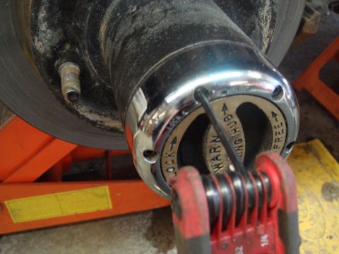 1996 Ford Bronco - A tool is used to adjust the front wheel hub, showing the "WARN" and "LOCK" settings.