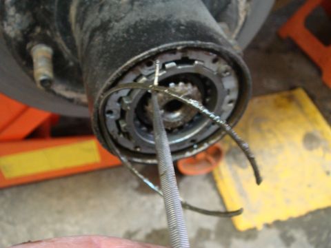 1996 Ford Bronco - A tool is used to manipulate a spring on a vehicle's front wheel hub assembly.