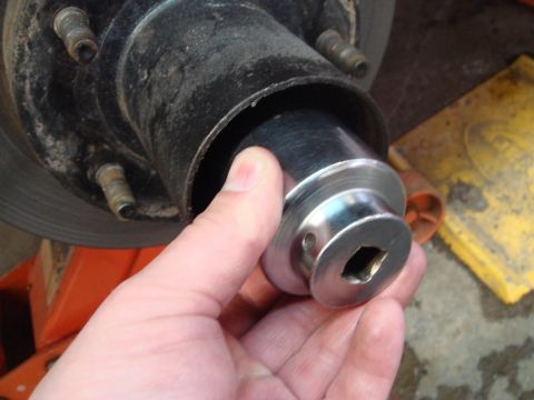 1996 Ford Bronco - Socket wrench being used on a vehicle's wheel hub, likely for maintenance or repair.