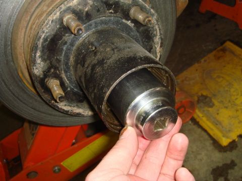 1996 Ford Bronco - Socket wrench being used on a vehicle's wheel hub assembly.