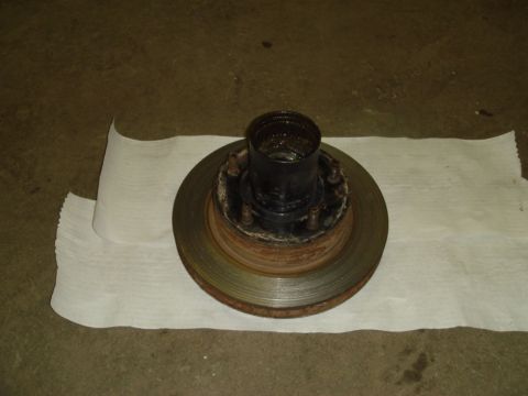 1996 Ford Bronco - Brake rotor and hub assembly resting on paper towels on a concrete floor.