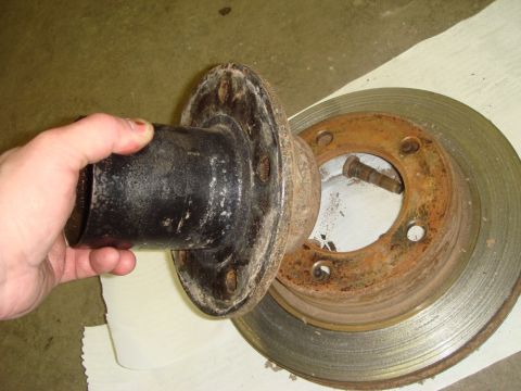 1996 Ford Bronco - A rusty brake rotor and a black hub assembly are shown, held by a hand.