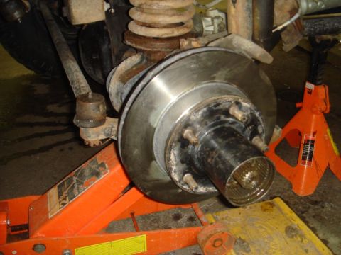 1996 Ford Bronco - Front wheel hub and brake rotor assembly on jack stands, likely undergoing maintenance.