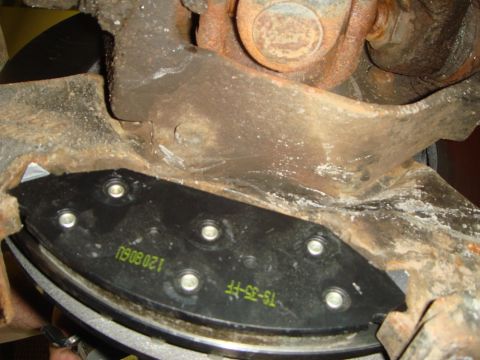 1996 Ford Bronco - A new brake pad is installed on a vehicle's rusty brake assembly.