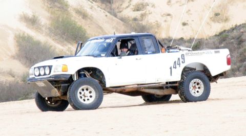 1984 Ford Bronco - This off-road pickup truck, marked with the number 1449, navigates a sandy terrain.