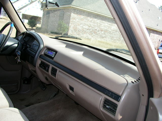 Tan dashboard and steering wheel of a 1995 Ford Bronco, showing the radio and air vents