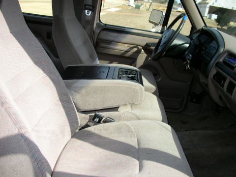 1995 Ford Bronco - The interior of this 1995 Ford Bronco features cloth seats and a center console with cup holders.