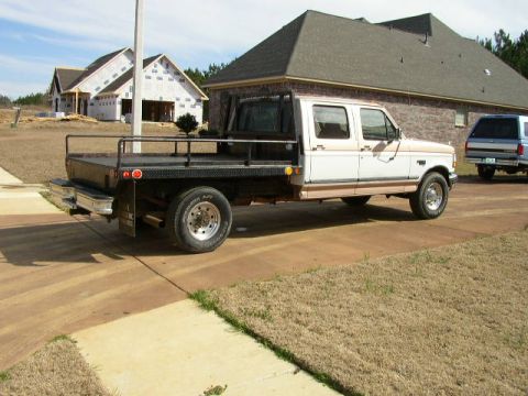 1995 Ford Bronco - This Ford F-350 crew cab features a flatbed and is parked in front of a house under construction.