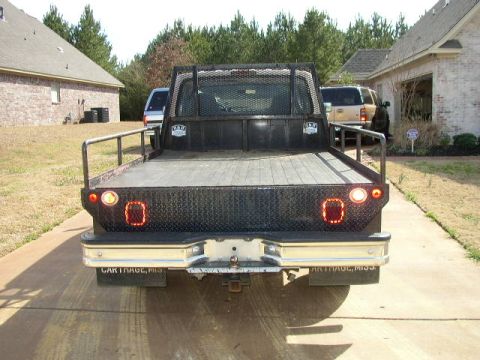 1995 Ford Bronco - This flatbed truck has a diamond plate bed and chrome bumper. The license plate frame reads 'CARTHAGE, MISS'.