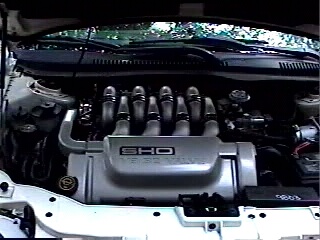 1997 Ford Taurus - The engine compartment of a 1997 Ford Taurus SHO is visible, highlighting the V6 engine's intake manifold.