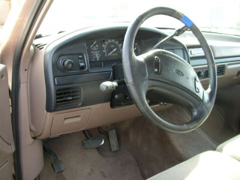 1995 Ford Bronco - The interior of a 1995 Ford truck, the dashboard, steering wheel, and driver's side controls.
