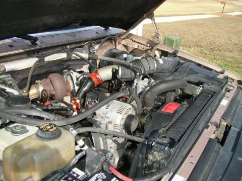 1995 Ford Bronco - The engine bay of a truck, a turbocharger and other engine components under the hood.