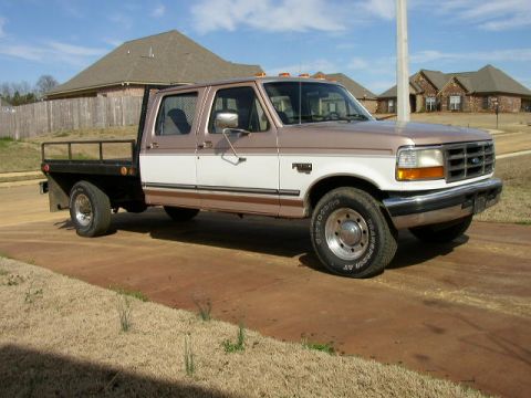 1995 Ford Bronco - This 1997 Ford F-350 Super Duty Crew Cab flatbed truck is shown from a 3/4 front angle.