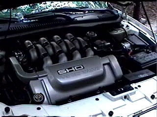 1997 Ford Taurus - Engine bay view of a SHO V8 engine cover, with visible text and branding.
