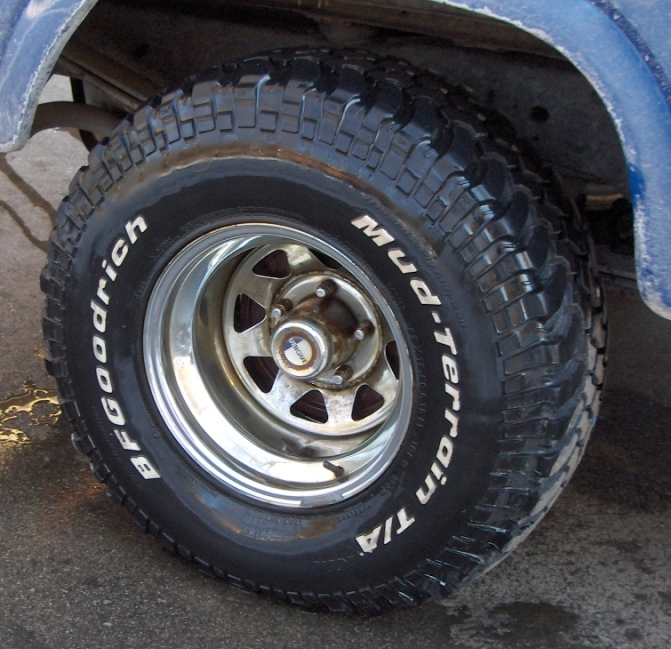 BFGoodrich Mud-Terrain T/A tire on a chrome five-spoke rim, part of a blue vehicle