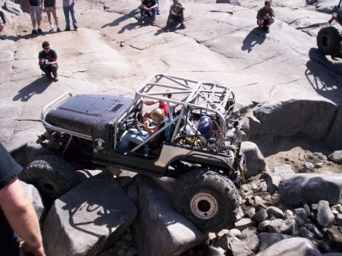 1989 Ford Bronco - This heavily modified off-road vehicle is shown tackling a challenging rocky obstacle course.